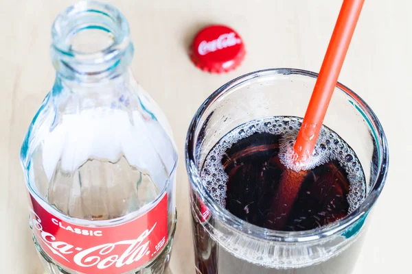 Bevanda in bicchiere con paglia e bottiglia di Coca-Cola — Foto Stock