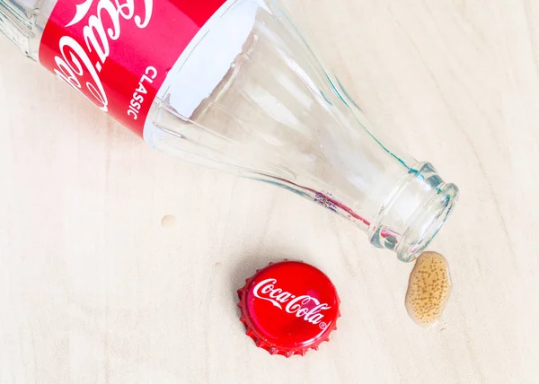 Tampa vermelha, garrafa vazia de Coca-Cola e gota de bebida — Fotografia de Stock