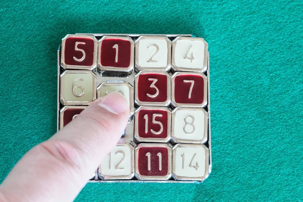 Finger slides tile in 15-puzzle sliding puzzle — Stock Photo, Image
