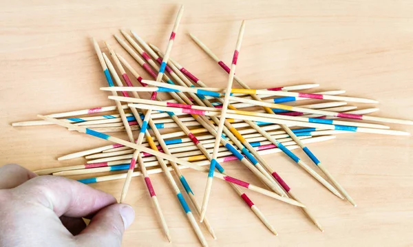 Player picks up a stick from pile in Mikado game — Stock Photo, Image