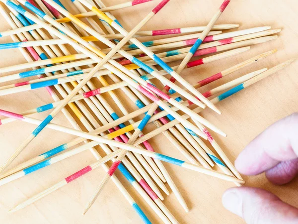 Player picks up a stick in Mikado game close up — Stock Photo, Image