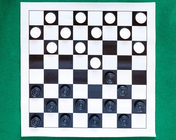 Top view of checkers on black and white sheet — Stock Photo, Image