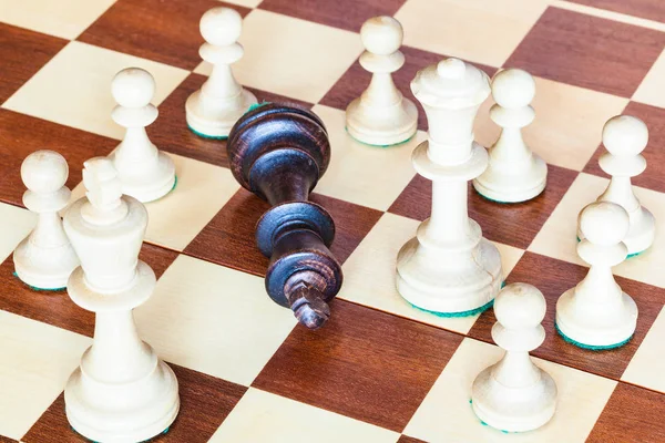 Schwarzer König fällt und weiße Schachfiguren gewinnt — Stockfoto
