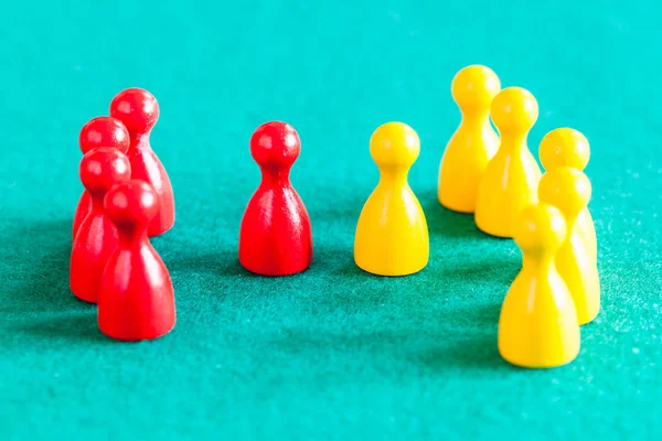 Few red pawns in front of several yellow pawns — Stock Photo, Image