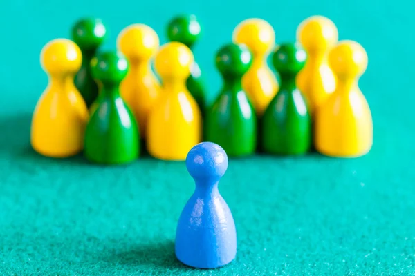 One blue pawn in front of other color pawns — Stock Photo, Image