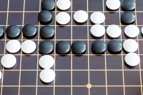 playing in Go game on wooden board
