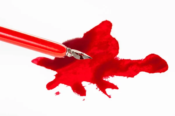 Kırmızı mürekkep lekesi üzerinde kırmızı daldırma kalem keskin ucu — Stok fotoğraf