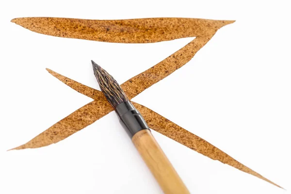 Kahverengi fırça darbeleri üzerinde kahverengi ucu ile paintbrush — Stok fotoğraf