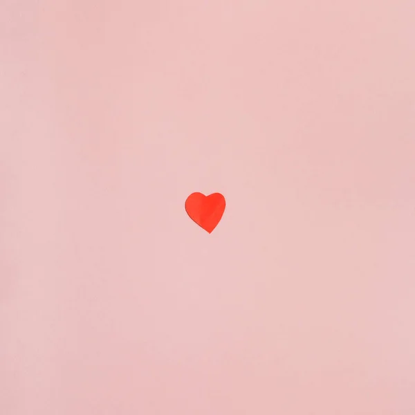 Rött papper skär hjärta på ljusrosa papper — Stockfoto