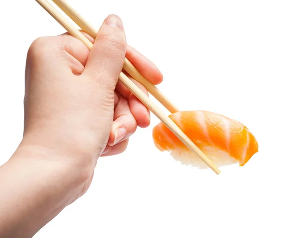 Bacchette di legno tengono nigiri sushi con salmone — Foto Stock