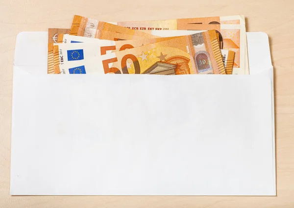 Flera 50 eurosedlar i kuvert på bordet — Stockfoto