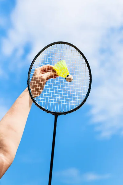 Female hand hits shuttlecock by badminton racquet — Stock Photo, Image