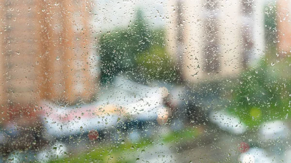 雨点落在窗玻璃和模糊的街道上 — 图库照片