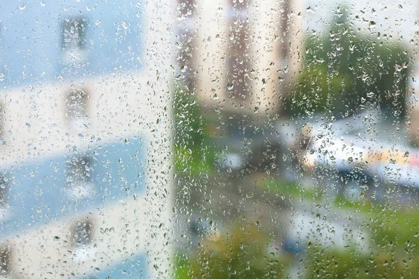 Esőcseppek az ablaküvegen és homályos város — Stock Fotó