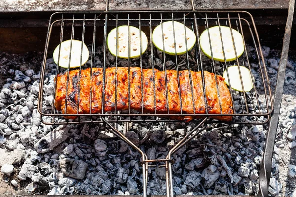 Costelas de porco cozinhando com abobrinha fatiada na grelha — Fotografia de Stock