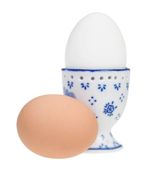 White boiled egg in ceramic egg cup and brown egg — Stock Photo, Image
