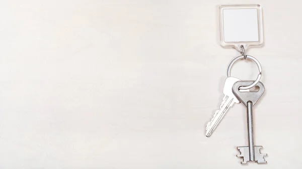 Keys on keyring with blank white keychain on board — Stock Photo, Image