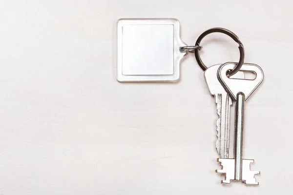 Bunch of keys on keyring with blank white keychain — Stock Photo, Image
