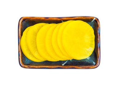 Beyaz arka planda izole edilmiş seramik kasede turşu turşusundan geleneksel Kore ve Japon Takuan (Danmuji) mezesi manzarası