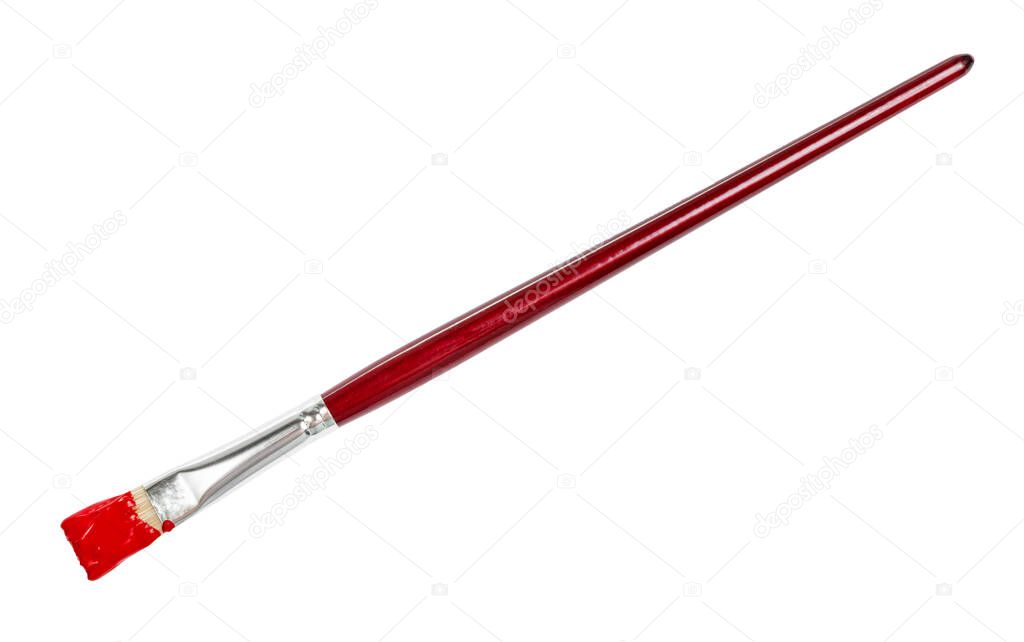 flat paint brush with red colored tip and brown handle isolated on white background