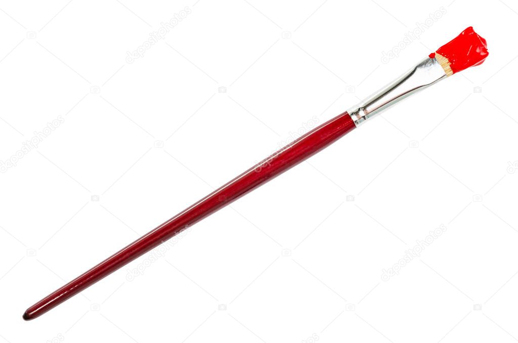 flat paint brush with red colored tip in blot and brown handle isolated on white background