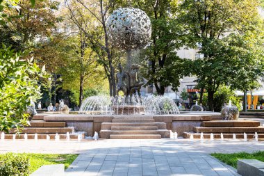 MOSCOW, RUSSIA - SEPTEMBER 6, 2020: Güneşli bir Eylül gününde Moskova 'da Pyatnitskaya Caddesi' ndeki yeşil bahçede Adem ve Havva çeşmesinin yakınındaki insanlar. Çeşme 2008 'de çalışmaya başladı.