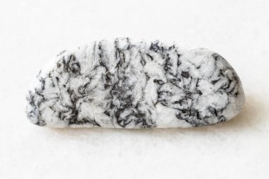 Jeolojik koleksiyondaki doğal mineral örneğinin yakın çekimi - Satkinskoe yatağı, Güney Urallar, Rusya 'dan beyaz mermer arka planda cilalanmış magnezit kaya