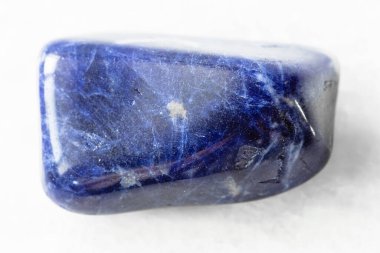 Jeolojik koleksiyondaki doğal mineral örneğinin yakın çekimi - Brezilya 'nın beyaz mermer arka planında cilalanmış Sodalite kayası