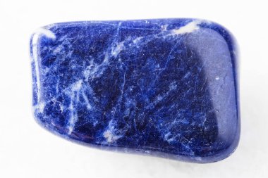 Jeolojik koleksiyondaki doğal mineral örneğinin yakın çekimi - Brezilya 'dan beyaz mermer arka planda yuvarlanan Sodalite kayası