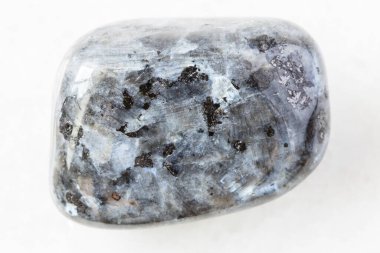 Norveç 'in beyaz mermer arka planında cilalanmış Larvikite (Norveç Labradoriti) doğal mineral numunesinin yakın çekimi