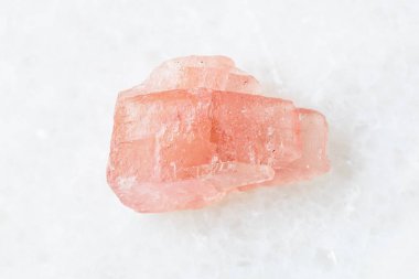 Jeolojik koleksiyondaki doğal mineralin yakın plan örneği - Wutong madeni, Liubao, Guangxi prov, Çin 'den beyaz mermer arka planda cilalanmamış Rhodochrosite kristali