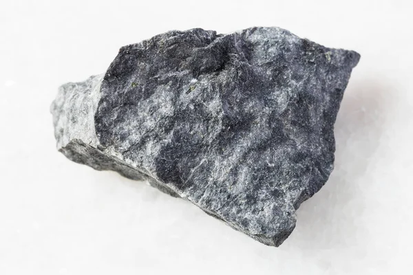 地质采集的天然矿物样品的特写 白色大理石背景下的粗灰色玄武岩 — 图库照片