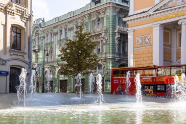 MOSCOW, RUSSIA - SEPTEMBER 27, 2020: Birzhevaya (Borsa) Meydanı 'nda Federal Hazine ve Ticaret Odası binaları ve İlyinka Caddesi' ndeki gezi otobüsü yakınlarındaki su kaynağı yüzeyi