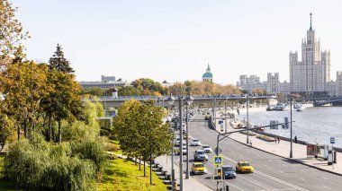 MOSCOW, RUSSIA - SEPTEMBER 27, 2020: Moskva Nehri 'nin Moskvoretskaya Embankment ve Zaryadye Peyzaj Parkı' nın Yüzen Köprüsü ve sonbaharda ufuk çizgisinde yüksek binalar