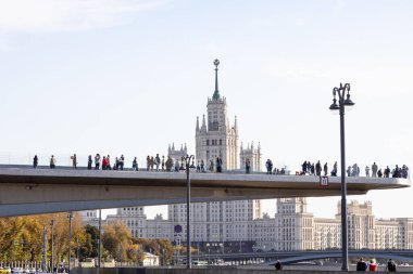 MOSCOW, RUSSIA - SEPTEMBER 27, 2020: Zaryadye Peyzaj Parkı ve Moskova 'daki Kotelnicheskaya Embankment yüksek binası yakınlarındaki turistlerin yer aldığı Yüzen Köprü