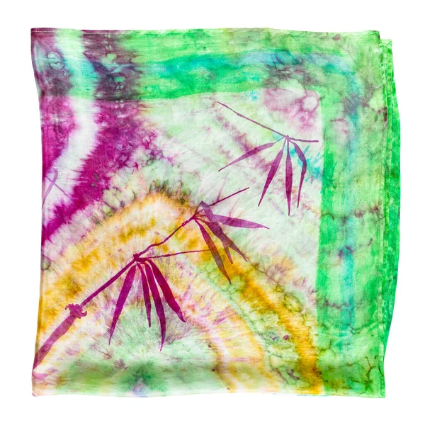 folded colorful colored batik silk scarf with hand-drawn bamboo twig isolated on white background