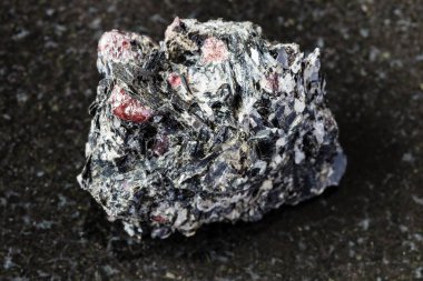 Jeolojik koleksiyondaki doğal mineral örneklerinin makro fotoğrafçılığı - Yelovyy Navolok, Shueretskoye yatağı, Karelia, Rusya 'da siyah granit üzerinde cilalanmamış kırmızı Garnet kristalleri