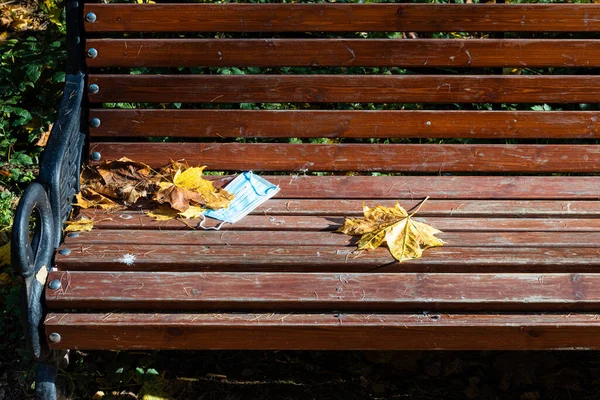 Övergiven Medicinsk Ansiktskolv Och Fallna Lönnlöv Träbänk Stadsparken Höstdagen — Stockfoto