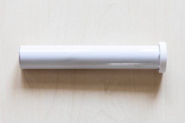 Ahşap tahtada yükselen haplar için kapalı beyaz silindirik konteynır