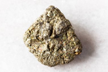 Beyaz mermer arka planda kesilmemiş pirit minerali örneği yakın plan