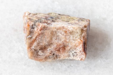 Beyaz mermer arka planda ham nephelin minerali örneği. Güney Urallar, Rusya 'dan yakın plan.