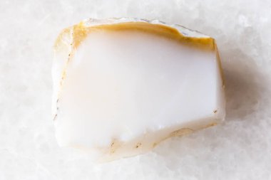 Beyaz mermer arka planda sert sütlü opal mineral örneği yakın plan