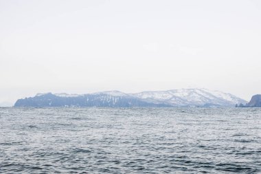 Su yüzeyi ve Pasifik Okyanusu 'ndaki Avacha Körfezi kıyısı ilkbahar günü Petropavlovsk-Kamçatsky şehri, Kamçatka Krai, Rusya