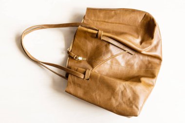 Düz deri çanta ahşap masada.