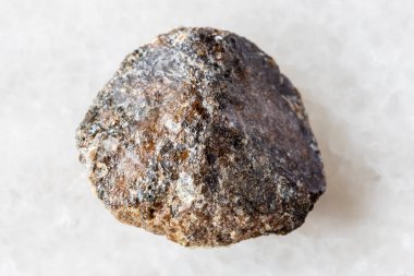 Beyaz mermer arka planda ham kahverengi titanit minerali örneği Khibiny, Kola Yarımadası, Rusya