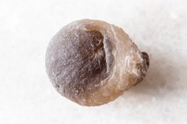 Beyaz mermer arka planda cilalanmamış akik mineral örneği yakın plan