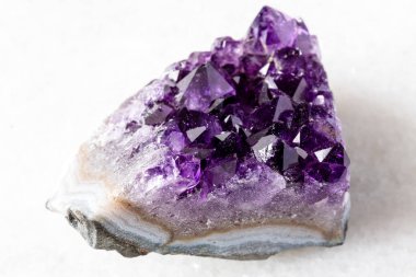 Rusya 'dan yakın plan beyaz mermer üzerinde kesilmiş ametist mineral kristalleri örneği
