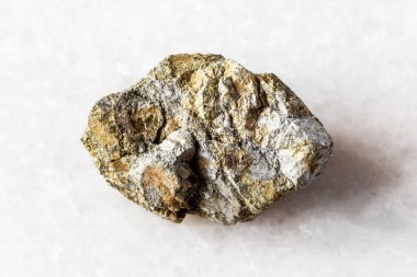 Beyaz mermer zemin üzerinde çalışmamış pirit taşı örneği yakın plan