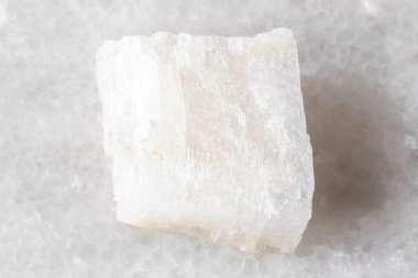 Dalnegorsk, Primorye, Rusya yakınlarındaki beyaz mermer zemin üzerinde çiğ renksiz kalsit kayası örneği