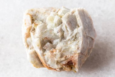 sample of raw albite mineral on white marble background close up from North Karelia, Russia